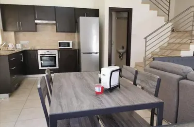 a kitchen with a wooden table and a kitchen with a dining room at BG04 Mythical Sands in Paralimni