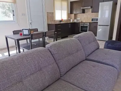 a living room with a couch and a kitchen at BG04 Mythical Sands in Paralimni