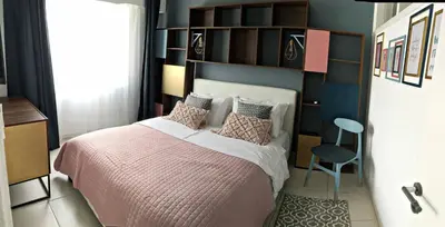 a bedroom with a bed and a blue wall at Cozy Getaway in Nicosia in Yukarı Lakatamya