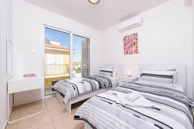 two beds in a room with a window at Villa Elaine in Paralimni