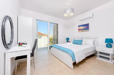 a bedroom with a bed and a desk and a mirror at Villa Elaine in Paralimni