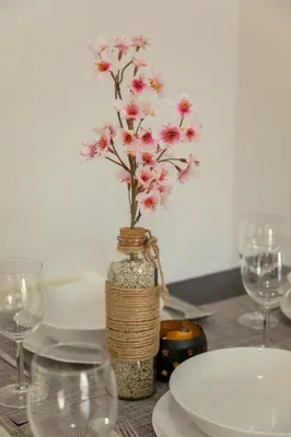 a table with a vase with pink flowers in it at Andriana City Centre Flat in Larnaka