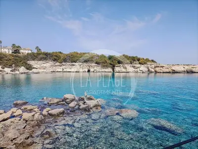 a beach with blue water and rocks in the ocean at ♥ Sunny&Cozy Family Apartment ★ Walk to the Beach☼ in Paralimni