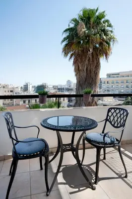 a glass table and two chairs on a patio at Welcome! Perfect Location-City Center in Larnaka
