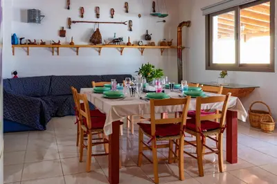 a dining room with a table and chairs at BerryRose Villa in Pervolia
