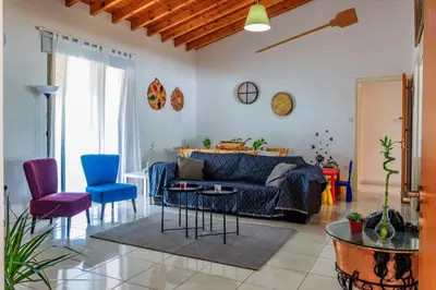 a living room with a blue couch and chairs at BerryRose Villa in Pervolia
