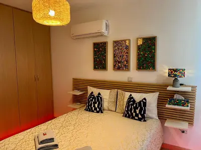 a bedroom with a bed with pillows on it at Fat Cow Apartment 103 in Larnaka