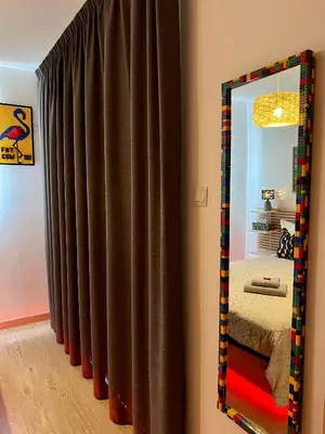 a mirror in front of a brown curtain in a room at Fat Cow Apartment 103 in Larnaka