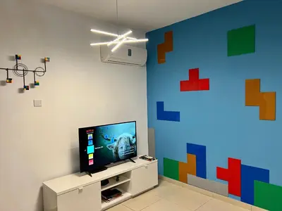 a living room with a tv and a colorful wall at Fat Cow Apartment 103 in Larnaka
