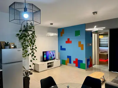 a living room with a pixelated wall and a tv at Fat Cow Apartment 103 in Larnaka