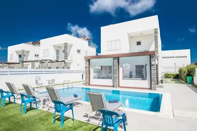 a villa with a swimming pool and chairs at Villa Anemoni 8 in Protaras