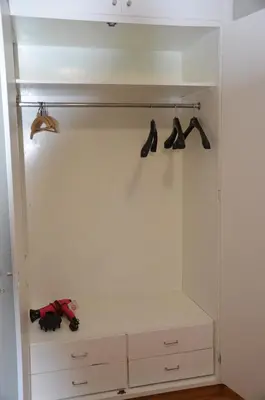 a white closet with hangers and shoes at Strovolos Value Suites in Strovolos