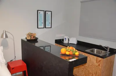 a kitchen with a sink and a bowl of fruit on a counter at Strovolos Value Suites in Strovolos