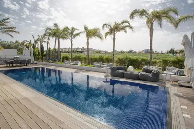 a swimming pool with palm trees in the background at Villa Chana in Protaras