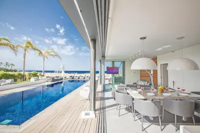 a dining room with a swimming pool and a dining table at Villa Chana in Protaras
