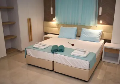 a bedroom with a bed with towels and shoes on it at Hai Hotel in Larnaka