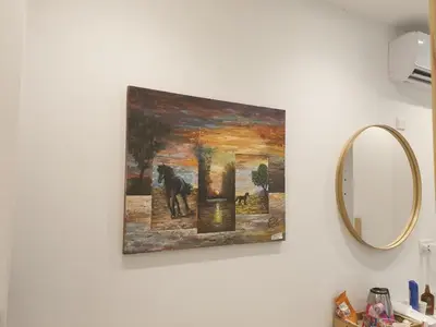 a painting hanging on a wall next to a mirror at Hai Hotel in Larnaka