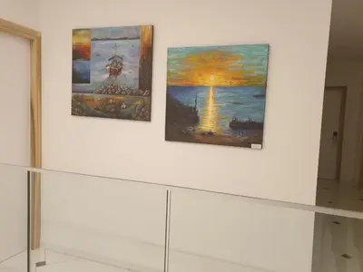 three paintings on a white wall in a room at Hai Hotel in Larnaka