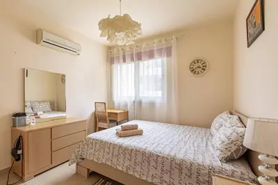a bedroom with a bed and a dresser and a mirror at Lovely Bedroom in shared apartment Oroklini in Voroklini