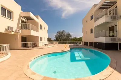 a large swimming pool in the middle of a building at Lovely Bedroom in shared apartment Oroklini in Voroklini