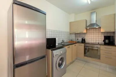 a kitchen with a stainless steel refrigerator and a washer at Lovely Bedroom in shared apartment Oroklini in Voroklini