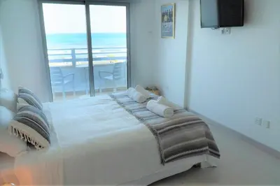 a bedroom with a bed with a view of the ocean at Larnaka Seaview Luxury Suites in Larnaka