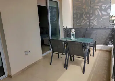 a glass table and chairs in a room with a window at Mythical Sands Luxury Apartment in Paralimni