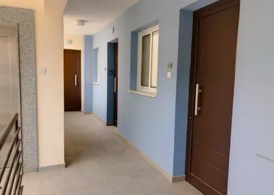a hallway with blue walls and a door at Mythical Sands Luxury Apartment in Paralimni