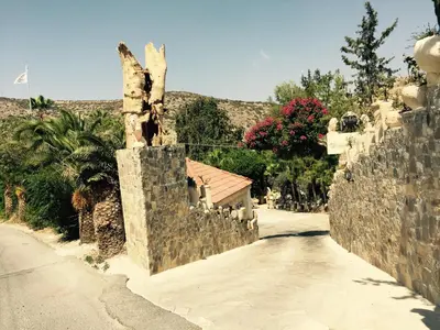 a stone fence and a road with a house at Greenfields Country Club in Limassol