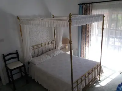 a bedroom with a canopy bed and a chair at Greenfields Country Club in Limassol