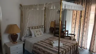 a bedroom with a canopy bed and a desk at Greenfields Country Club in Limassol