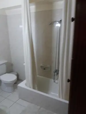 a bathroom with a shower curtain and a toilet at Greenfields Country Club in Limassol