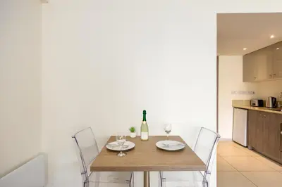 a dining room table with a bottle of wine and glasses at Melpo Antia Hotel & Suites in Ayia Napa