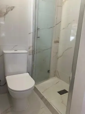 a white bathroom with a toilet and a shower at SUNNY COAST in Paralimni