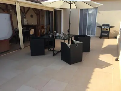 a room with a table and chairs and an umbrella at 2 Bed Flat - Sleeps 4 - Pool - Parking - Wifi in Xylophaghou