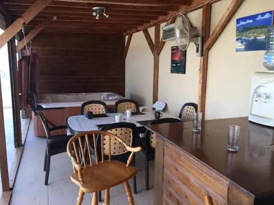 a dining room with a table and chairs and a tub at 2 Bed Flat - Sleeps 4 - Pool - Parking - Wifi in Xylophaghou