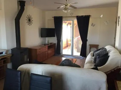 a living room with a couch and a tv at 2 Bed Flat - Sleeps 4 - Pool - Parking - Wifi in Xylophaghou