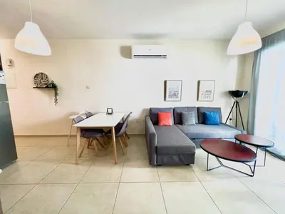 a living room with a couch and a table at Mythical Sands new Luxury Apartment in Paralimni