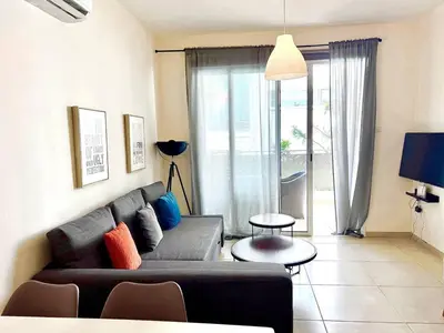 a living room with a couch and a table at Mythical Sands new Luxury Apartment in Paralimni