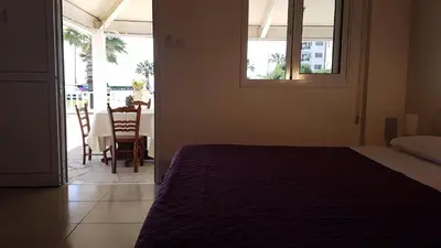a bedroom with a bed and a table and chairs at ZORBAS Sea View No 1 - Antoniella in Larnaka