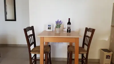 a table with two bottles of wine and two chairs at ZORBAS Sea View No 1 - Antoniella in Larnaka