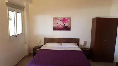 a bedroom with a bed with a purple blanket at ZORBAS Sea View No 1 - Antoniella in Larnaka