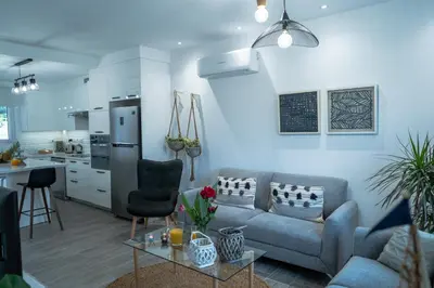 a living room with a couch and a kitchen at Andreotis Villas in Protaras