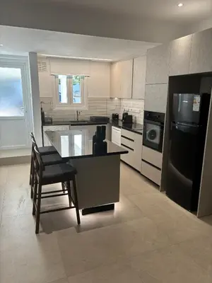 a kitchen with a table and a black refrigerator at Andreotis Villas in Protaras