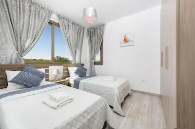 a hotel room with two beds and a window at Levanda #40 in Protaras