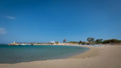 a beach with a bunch of chairs and the ocean at Levanda #40 in Protaras