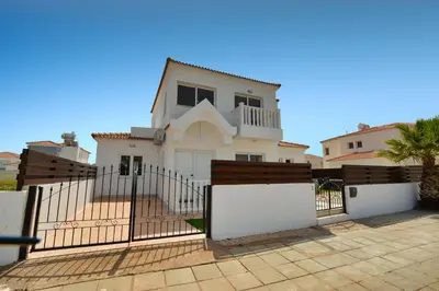 a white house with a gate and a fence at Villa Nissi Gold in Ayia Napa