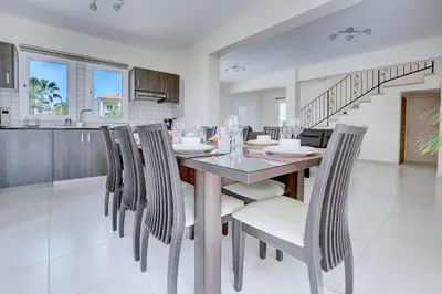 a kitchen and dining room with a table and chairs at Nissi Palms Villa in Ayia Napa