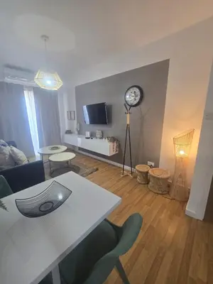 a living room with a table and a clock on the wall at Lazuli Sea View Beachfront- Ap 61 in Larnaka