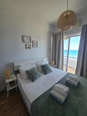 a bedroom with a bed with a view of the ocean at Lazuli Sea View Beachfront- Ap 61 in Larnaka